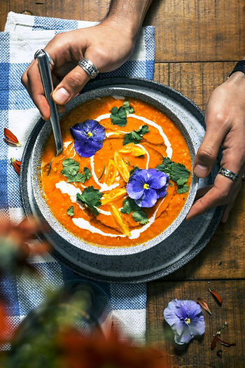 Wärmende, pürierte Gemüsesuppe mit Kräutern und essbaren Blüten